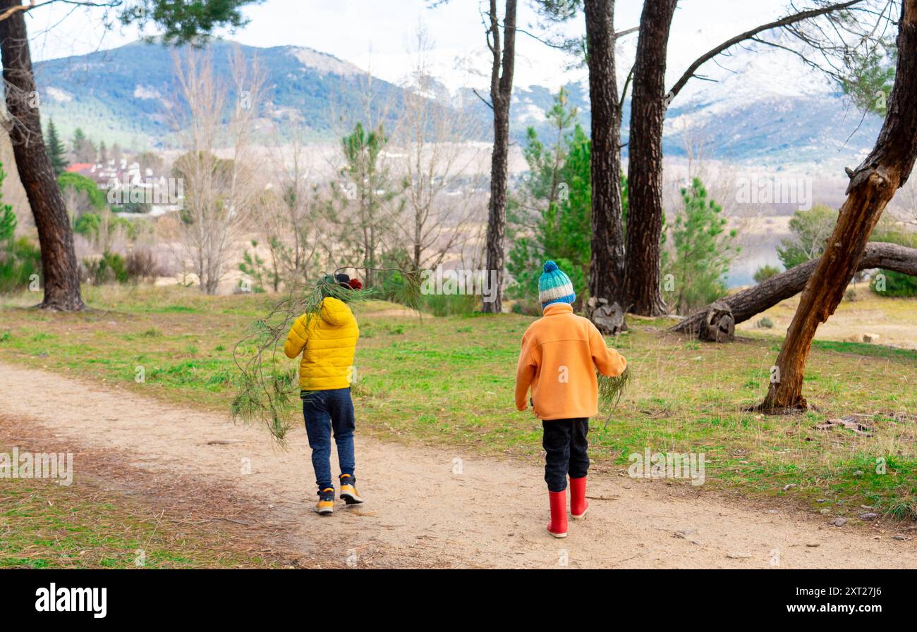 Due bambini irriconoscibili che giocano in natura in una giornata fredda Foto Stock