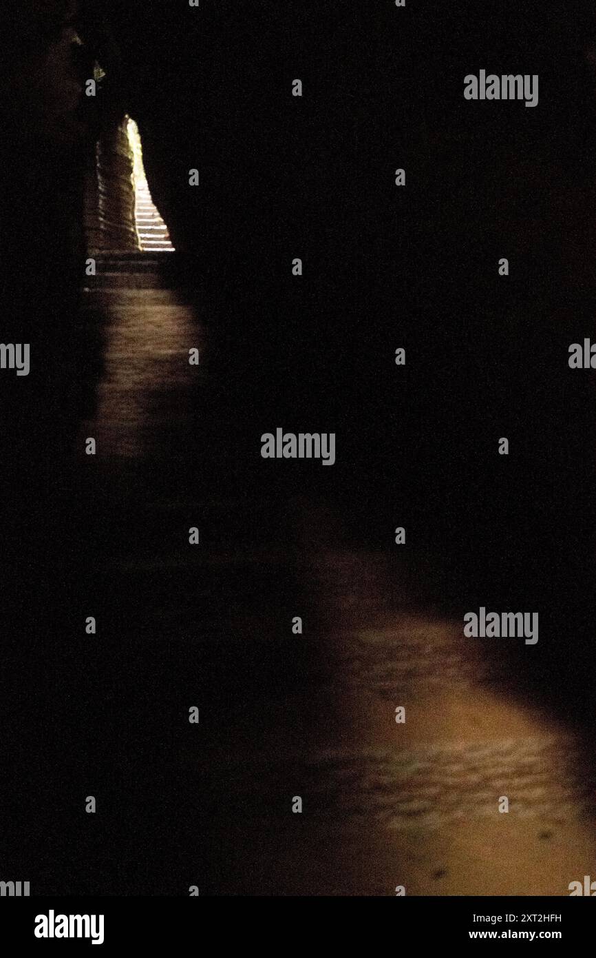 Stretto sentiero in pietra che si snoda attraverso formazioni rocciose che conducono verso l'alto in un ambiente naturale isolato Foto Stock