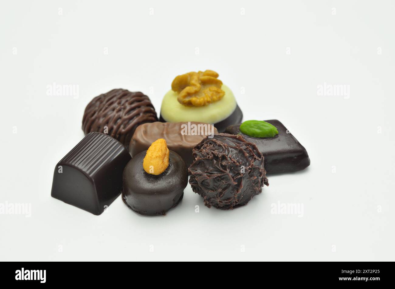Diversi tipi di praline al cioccolato, primo piano, isolate su sfondo bianco Foto Stock