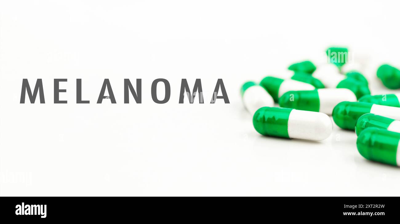 Un mucchio di pillole con sopra la parola Melanoma. Le pillole sono verdi e bianche Foto Stock
