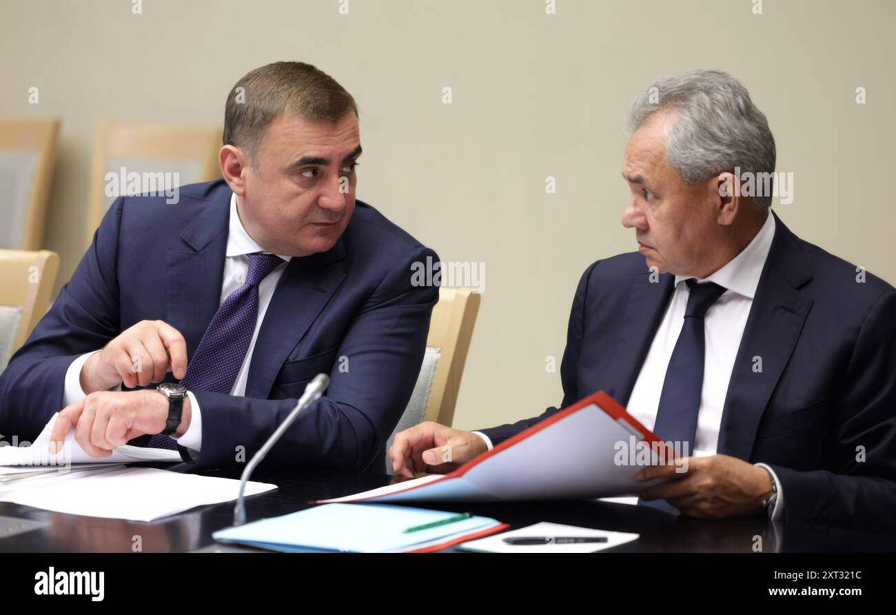 Novo-Ogaryovo, Russia. 12 agosto 2024. Il segretario del Consiglio di sicurezza russo Sergei Shoigu, a destra, ascolta il presidente Aide Alexei Dyumin, a sinistra, prima di una riunione con il presidente Vladimir Putin e i funzionari del governo per discutere dell'incursione militare Ucraina nella regione di Belgorod nella residenza presidenziale, il 12 agosto 2024, a Novo-Ogaryovo, Oblast di Mosca, Russia. Crediti: Gavriil Grigorov/piscina del Cremlino/Alamy Live News Foto Stock