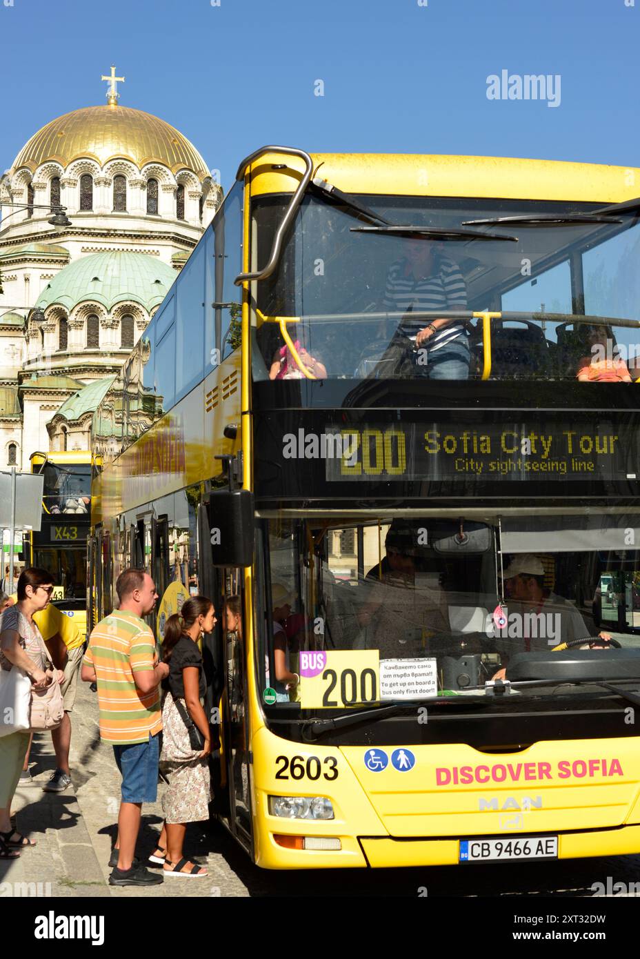 I turisti si imbarcano sull'autobus giallo del tour della città di Sofia presso Discover Sofia e presso la cattedrale di St. Alexander Nevsky a Sofia, Bulgaria, Europa Foto Stock