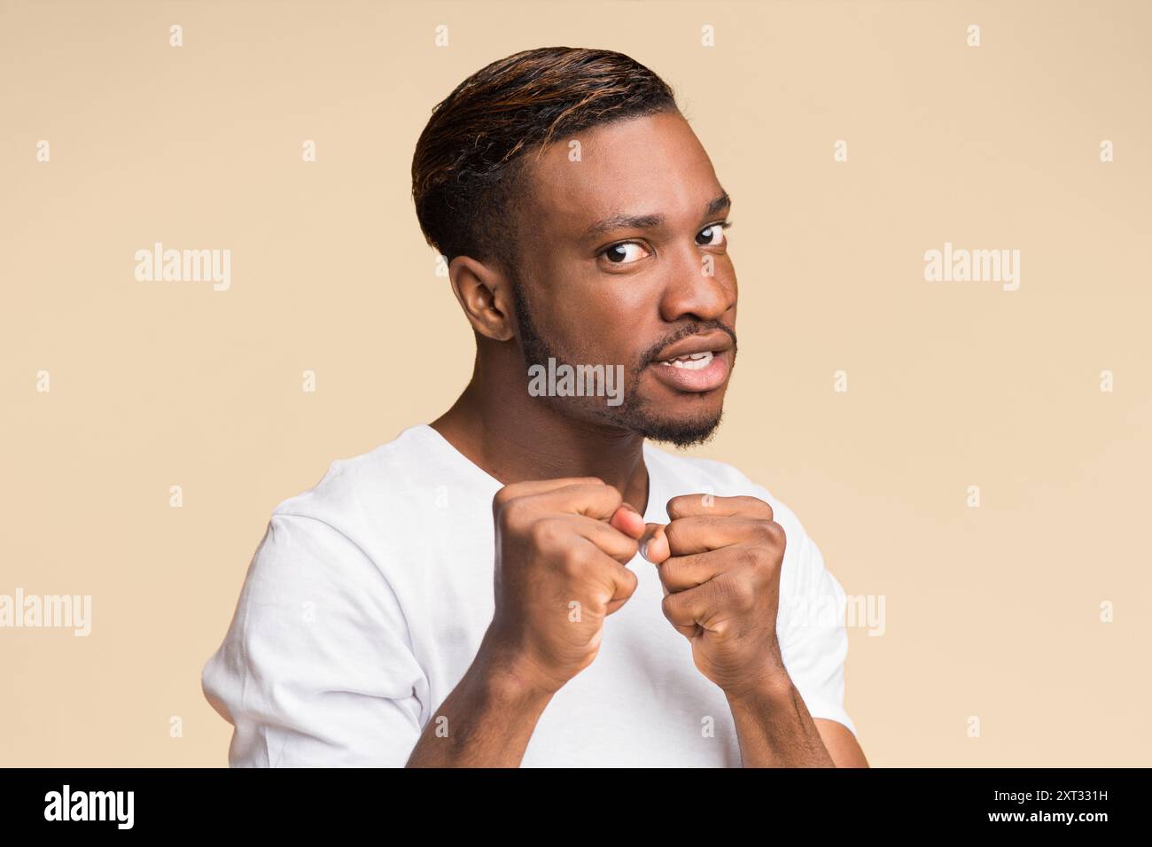 Ragazzo nero Clenching pugni pronti a lottare in piedi, Studio Shot Foto Stock