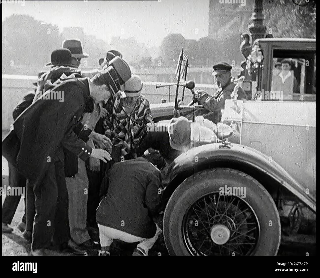 Scena del film "il marito obbligatorio": L'attore Monty Banks causa un incidente quando corre sopra un cane. Una folla di persone si riuniscono a Round the Car, 1920 anni "...la Francia dello sceneggiatore era una delle auto costose guidate da cani gay francesi come Monty Banks, che era italiano di origine comunque. Correndo sopra animali domestici, e/o bambini, la trama è stata condotta nei canali appropriati, con introduzioni tra coppie sposate, che hanno messo in moto un altro tipo di tumulto". Da "Time to Remember - Came the Dawn", 1925 (Reel 3); sbircia alla British Film Industry of the 1920s - cli Foto Stock