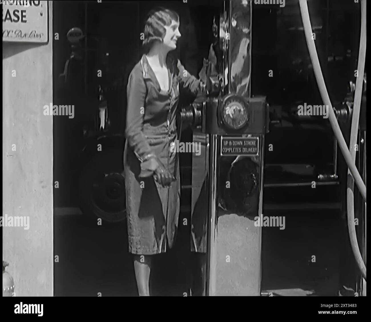 Civili donne che lavorano pompe di benzina in un garage, 1931. “Ogni giorno la vedeva [cioè la donna britannica media] entrare in nuove occupazioni. In un periodo di disoccupazione di massa, era una meraviglia che gli uomini non fossero più spesso in braccio a riguardo. Ma poi, un bel volto può spesso dare un forte impulso alle vendite". Da Time to Remember - A New era, 1931 (Reel 2); documentario sul mondo nei primi anni '1930 Foto Stock