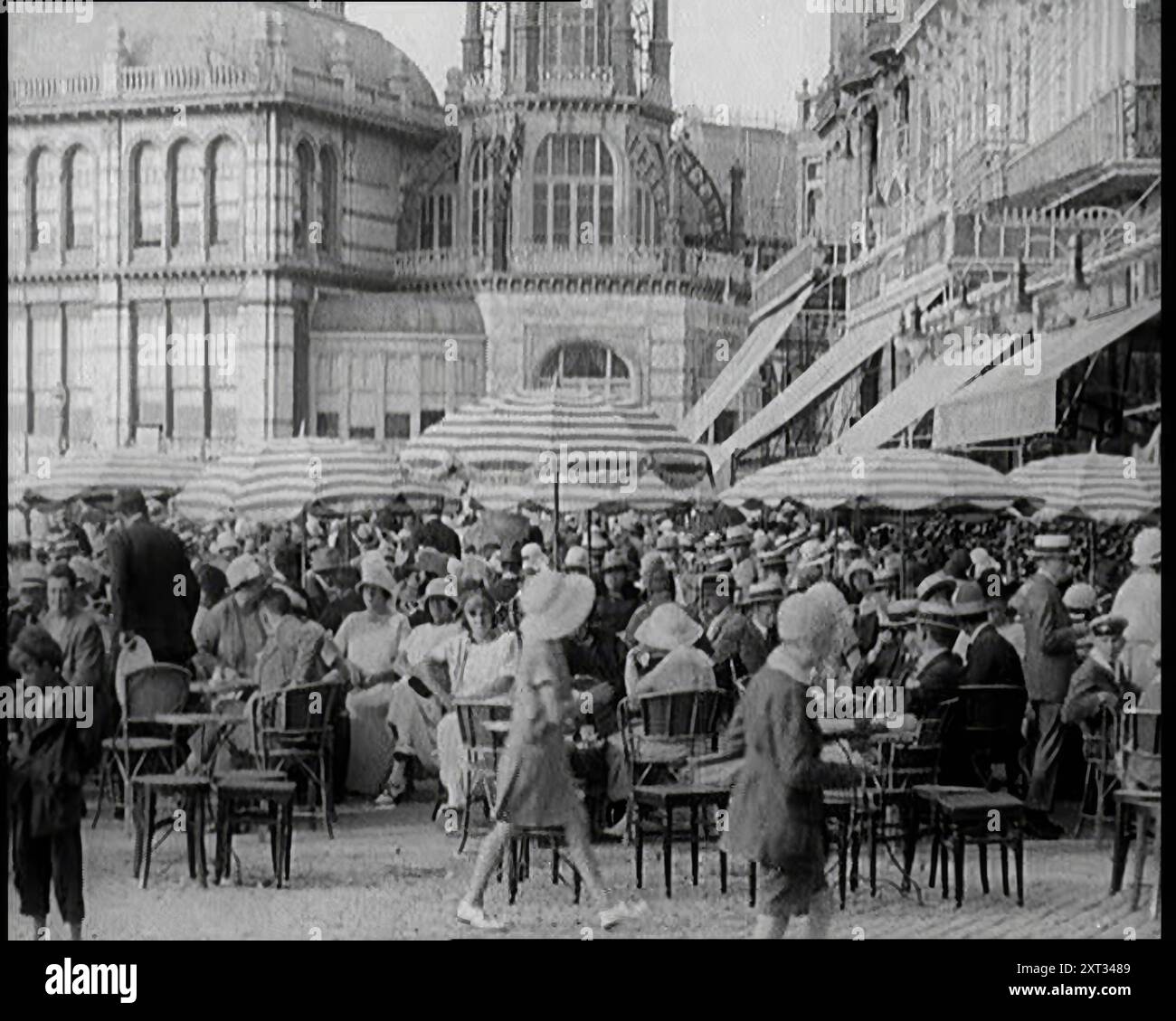 Scena del film "il marito obbligatorio": Folle di vacanzieri seduti nei caffè all'aperto degli anni '1920 "I visitatori di Deauville negli anni Venti potrebbero aver capito che era un posto piuttosto sfarzoso e rispettabile. AHA, ma non proprio la Deauville del paravento d'argento. Da Time to Remember - Came the Dawn, 1925 (Reel 3); dai un'occhiata all'industria cinematografica britannica degli anni '1920 - clip di grandi film muti e notiziari. Foto Stock