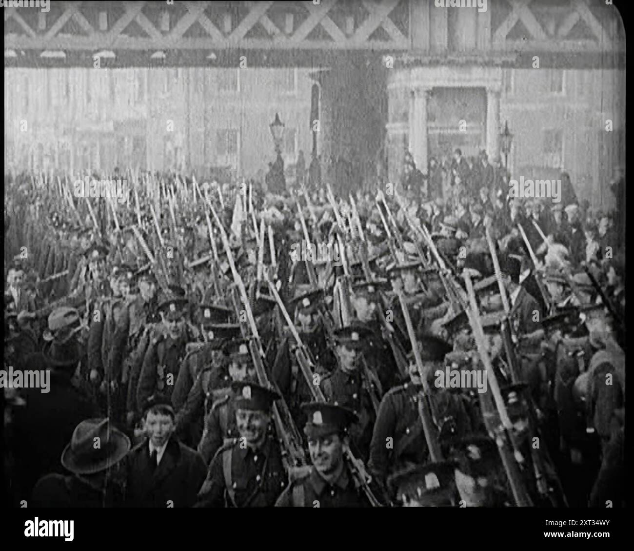 Soldati britannici che lasciano l'Irlanda, 1922. "Dopo anni di spargimento di sangue, fu firmato un trattato, e a Dublino, una nuova bandiera sostituì la bandiera dell'Unione. L'Irlanda, a parte le sei contee dell'Ulster, era diventata lo Stato libero d'Irlanda... scese le barriere e il filo spinato per così tanto tempo associato al dominio britannico e alle forze della corona, marciò per sempre. Dopo questi anni di tensione e di essere ceccati, i ragazzi (britannici) erano felici di andare. E, ammettiamolo, anche l'Irlanda era felice”. Da "Time to Remember - sitting STILL and going slow", 1922 (Reel 1); rassegna degli eventi del 1922 tra cui Irish Troubles, W Foto Stock