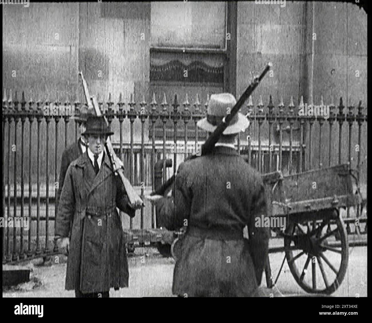 Soldati irlandesi dello Stato libero con i loro fucili sulle spalle, 1922. "Dopo anni di spargimento di sangue, fu firmato un trattato, e a Dublino, una nuova bandiera sostituì la bandiera dell'Unione. L'Irlanda, salvo le sei contee dell'Ulster, era diventata lo Stato libero d'Irlanda... lo Stato libero formò immediatamente il proprio esercito... migliaia si precipitarono ad arruolarsi. Era patriottico, ed era un lavoro... l'entusiasmo compensava la mancanza iniziale di attrezzature. Ed era un po' ironico che questi primi soldati di un'Irlanda libera indossassero il cachi britannico, tinti di verde. Da "tempo per ricordare - stare seduti fermi e andare lentamente", 1922 (Reel 1); Foto Stock