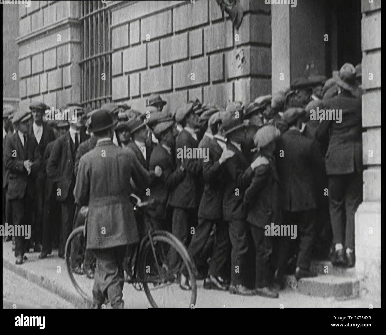 Lunghe code di uomini irlandesi in attesa di arruolarsi nel nuovo Esercito dello Stato libero, 1922. "Dopo anni di spargimento di sangue, fu firmato un trattato, e a Dublino, una nuova bandiera sostituì la bandiera dell'Unione. L'Irlanda, salvo le sei contee dell'Ulster, era diventata lo Stato libero d'Irlanda... lo Stato libero formò immediatamente il proprio esercito... migliaia si precipitarono ad arruolarsi. Era patriottico, ed era un lavoro... l'entusiasmo compensava la mancanza iniziale di attrezzature. Ed era un po' ironico che questi primi soldati di un'Irlanda libera indossassero il cachi britannico, tinti di verde. L'Irlanda del Sud era libera, e l'Irlanda si rallegrava”. Da "tempo a ricordare" Foto Stock