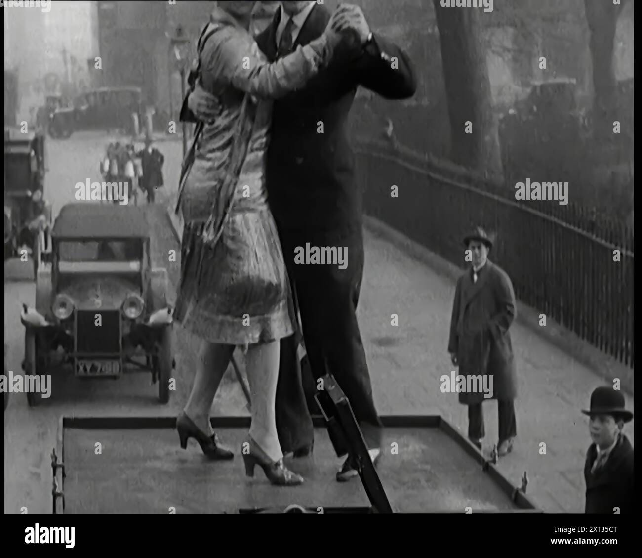 Una coppia che danzava il Charleston sulla cima di un'auto che percorreva una London Street, 1926. Da "Time to Remember 1926 - Short Sharp Shower" ( Reel 4); documentario sul 1926 - General Strike, International Politics, Dancing, Weather and record feats. Foto Stock