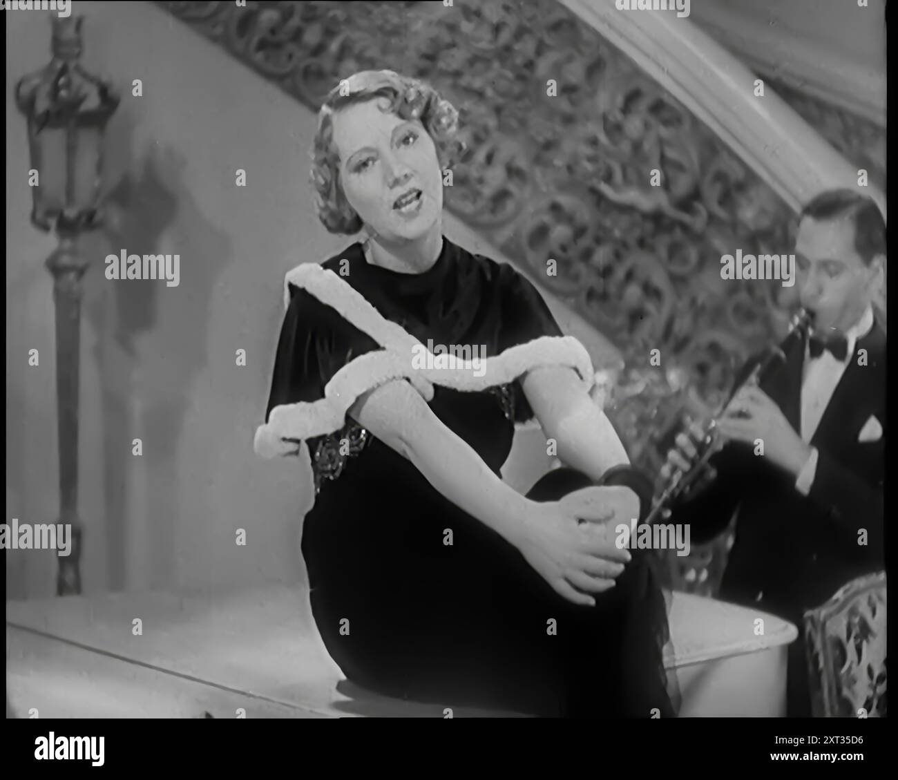 La cantante Elsie Carlisle e la sua band che eseguono una canzone sul suo ragazzo che è andato fuori con "The Girl Next Door", 1931. "Mi chiamava la fidanzata, pensavo che il suo amore fosse divino. Ma ora ha trovato un'altra ragazza, nella casa accanto alla mia. Gli piacevano i miei baci, voleva sempre di più. Ma ora quando vuole baci, li prende dalla ragazza della porta accanto". Da Time to Remember - A New era, 1931 (Reel 1); documentario sul mondo nei primi anni '1930 Foto Stock