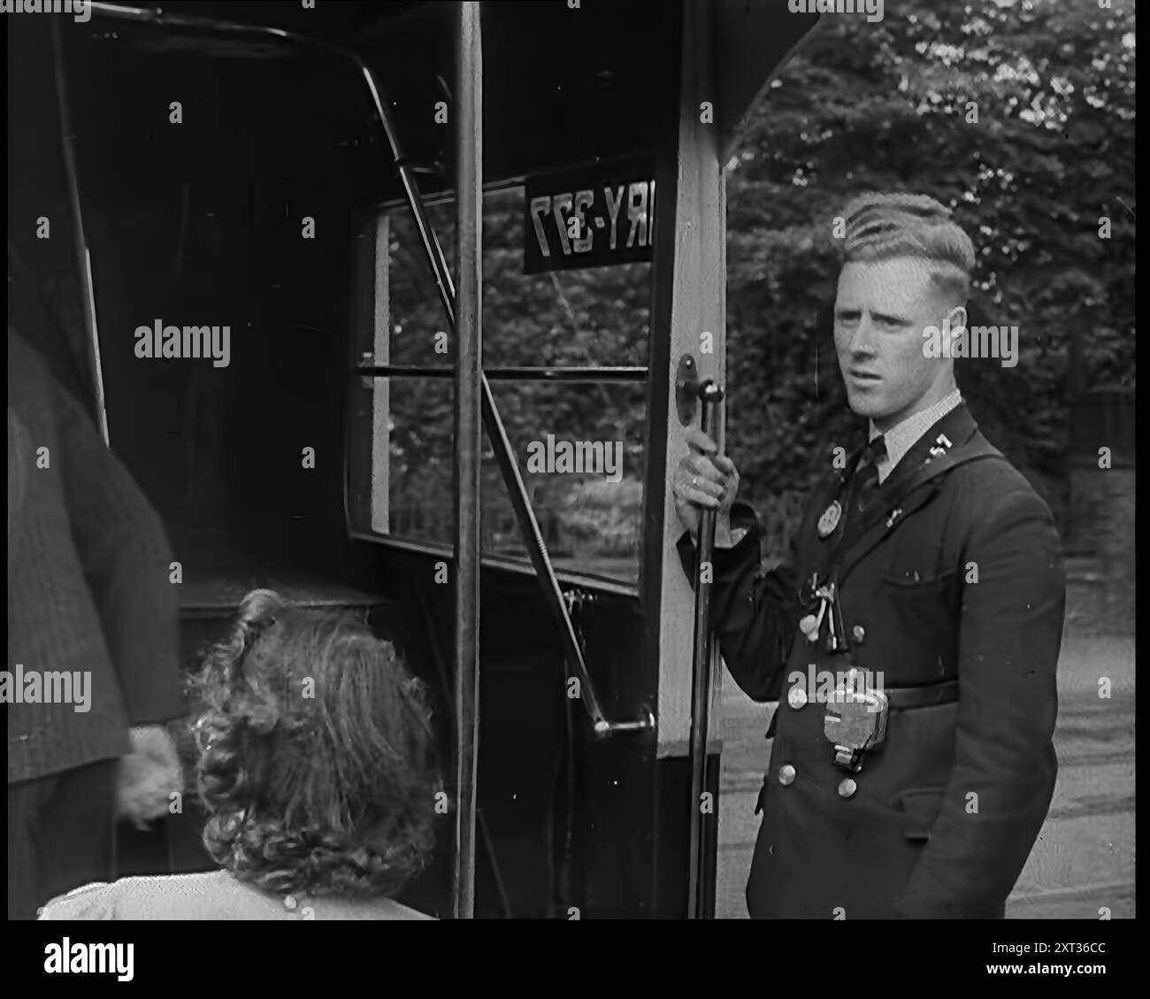 Conduttore bus, 1940. Regno Unito durante la seconda guerra mondiale: Il discorso di Churchill sulla minaccia della Germania nazista: "Tutta la furia e la forza del nemico devono presto essere rivoltati contro di noi. Hitler sa che dovrà spezzarci su quest'isola o perdere la guerra. Se riusciamo ad affrontarlo, tutta l'Europa potrebbe essere libera e la vita del mondo potrebbe andare avanti in vasti altopiani illuminati dal sole. Ma se falliamo, allora il mondo intero, inclusi gli Stati Uniti, compresi tutto ciò che abbiamo conosciuto e curato, affonderà nell'abisso di una nuova era oscura resa più sinistra, e forse più prolungata, dalla l Foto Stock