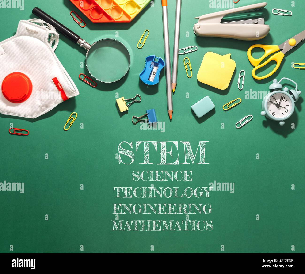 Uno sfondo verde con un mucchio di forniture scolastiche e le parole STEM, Scienza, tecnologia, Ingegneria e matematica Foto Stock