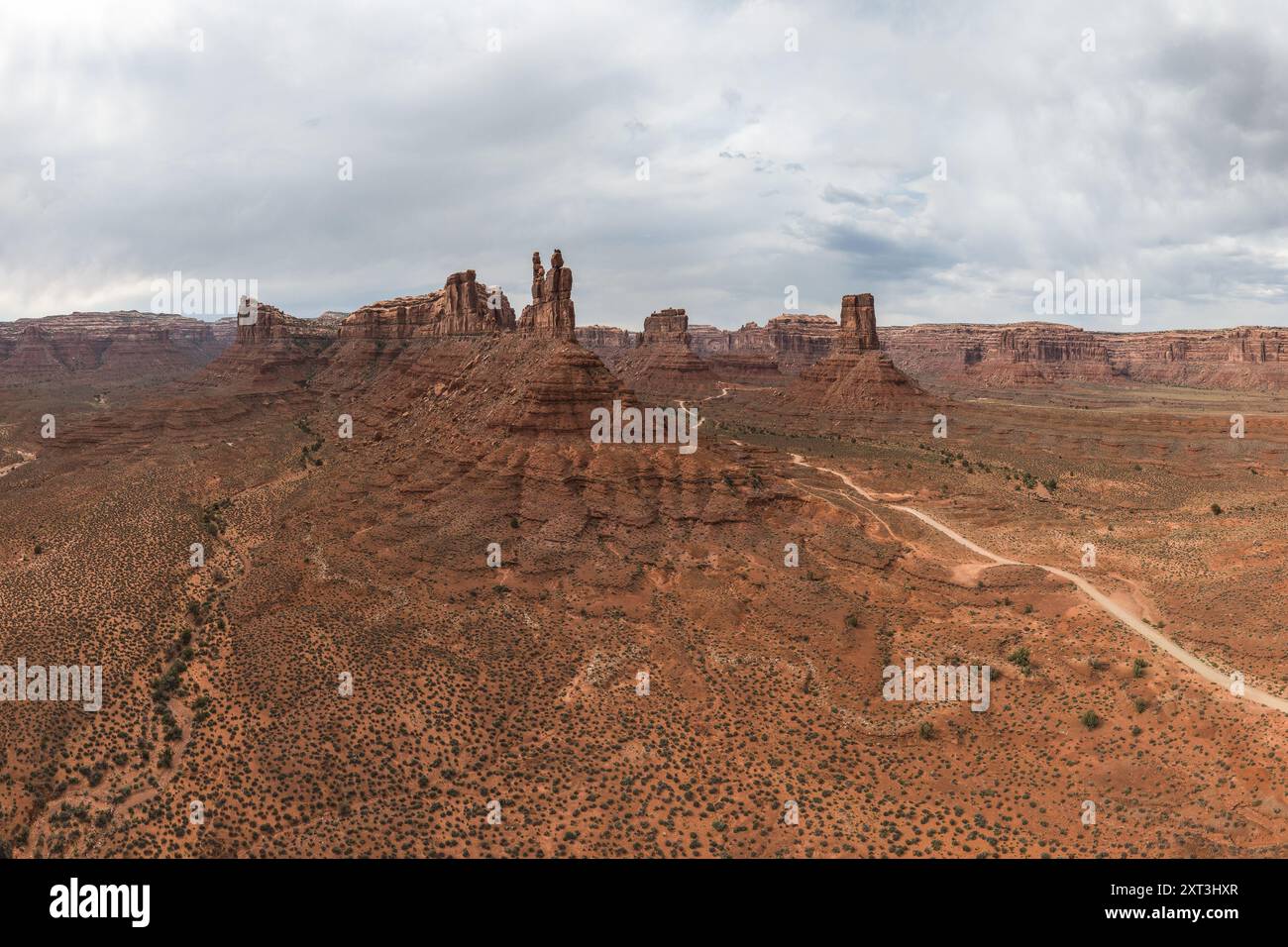 Una foto aerea panoramica che cattura l'aspra bellezza della Valle degli dei nello Utah, mostrando le iconiche formazioni di roccia rossa adagiate su un vasto e vasto terreno Foto Stock
