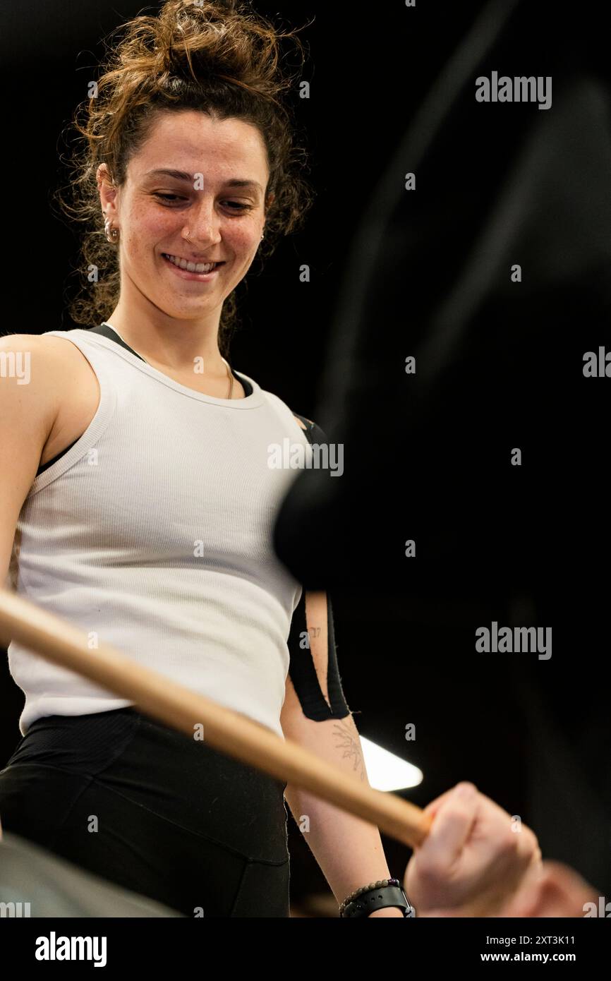 Questa immagine cattura una giovane donna allegra che si esercita in palestra, concentrandosi e preparandosi per un passaggio, con un'espressione concentrata e positiva Foto Stock