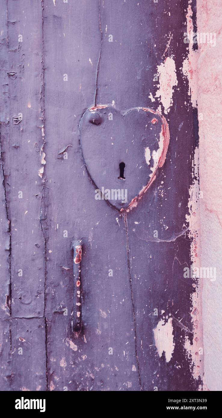 Antica porta con serratura a forma di cuore e maniglia. Foto tonificata. Foto Stock