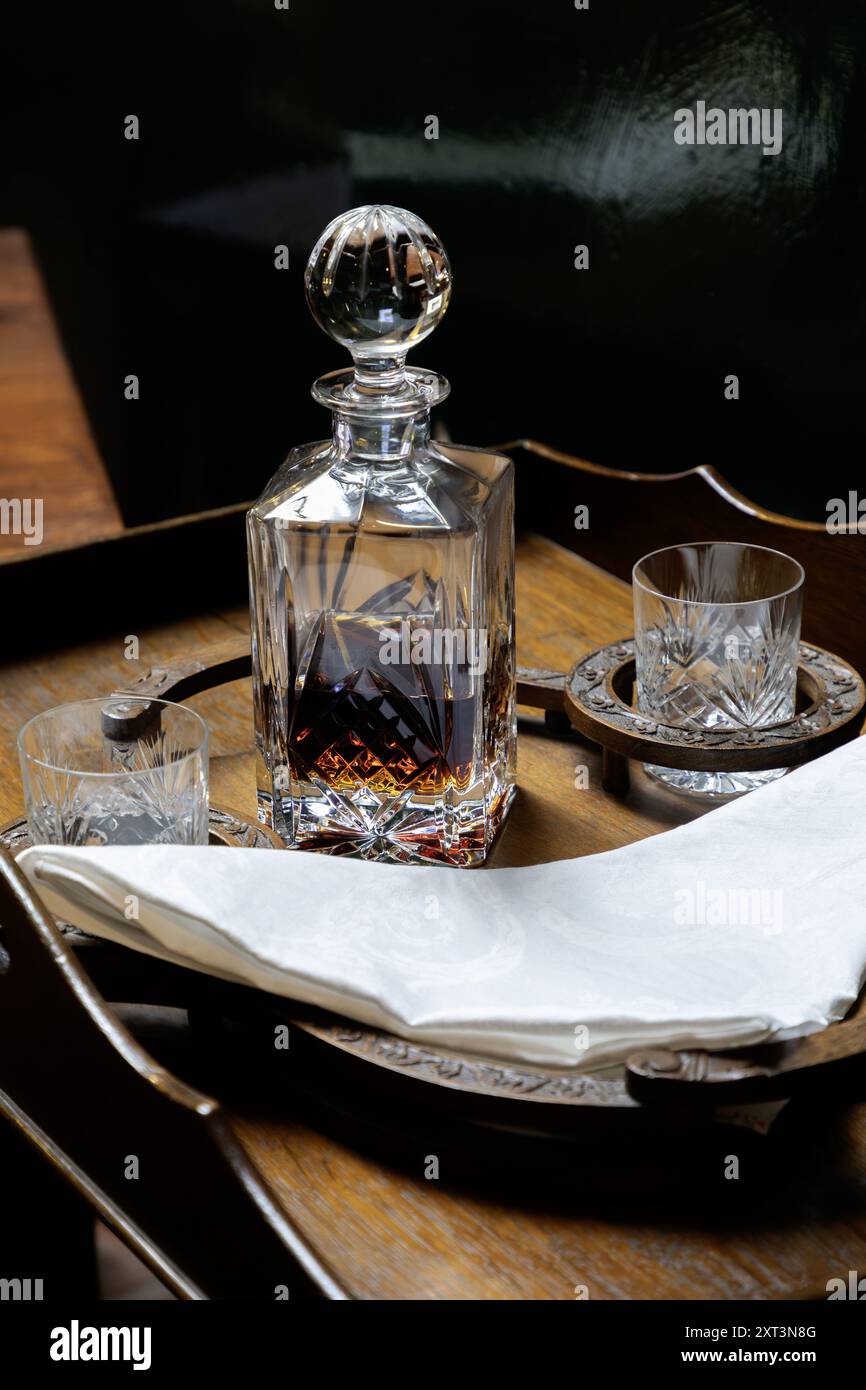 decanter e due bicchieri sono disposti su un piccolo tavolino Foto Stock