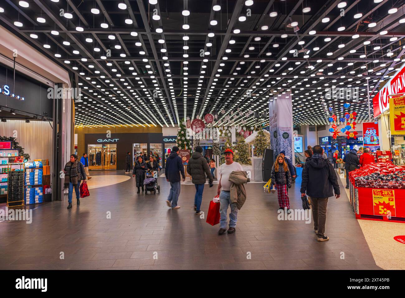 La sala dell'ipermercato di Natale è molto decorata, con boutique e negozi che camminano attraverso il corridoio con i loro acquisti. Svezia. Foto Stock