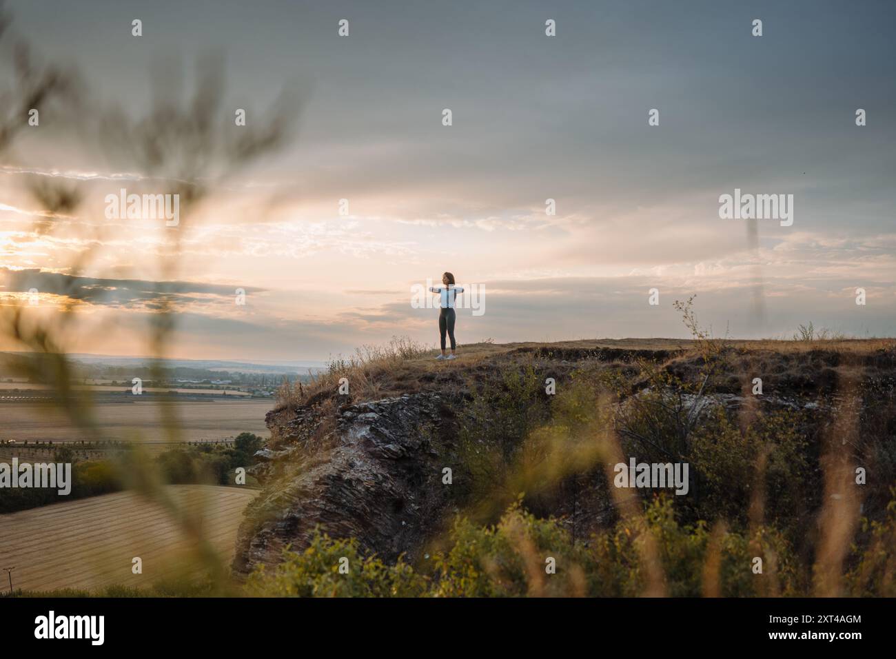 Sperimenta un senso di tranquillità e pace mentre osservi il tramonto dal bordo di una scogliera Foto Stock