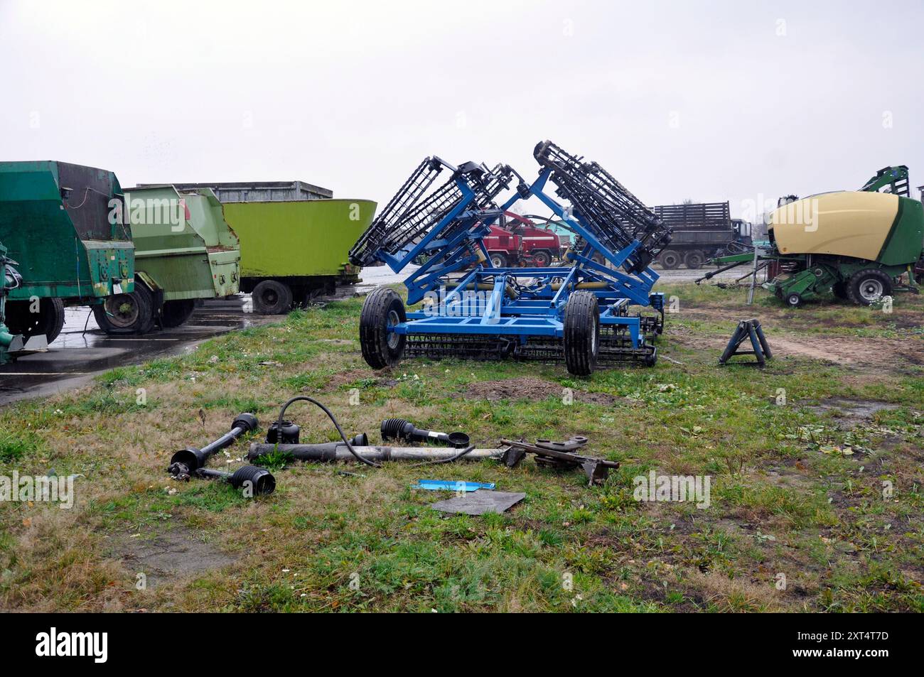 Una discarica di macchinari agricoli, componenti e assemblaggi nel cortile di un'organizzazione agricola. Foto Stock