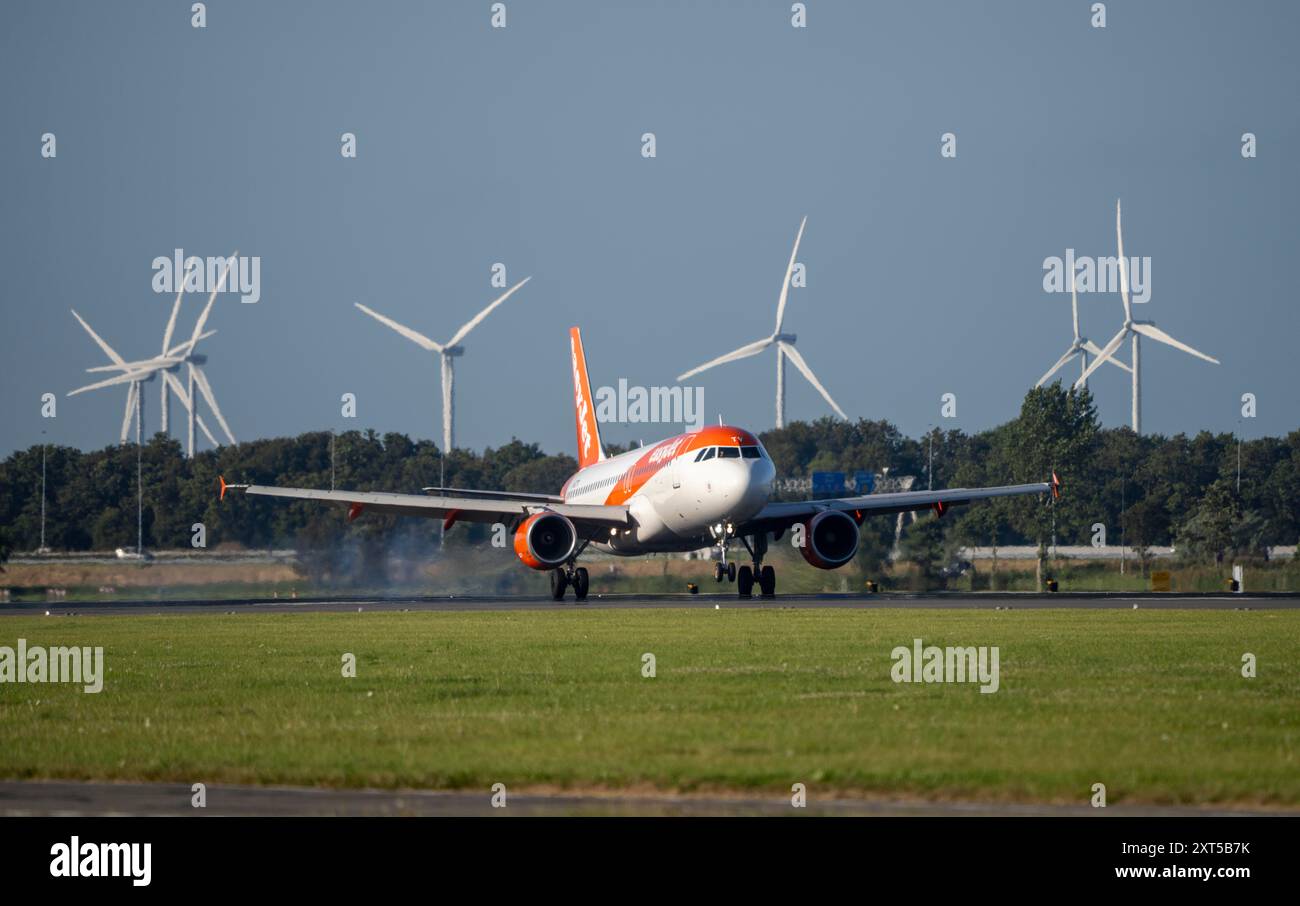 EasyJet atterra all'aeroporto Schiphol di Amsterdam, Polderbaan, 18R/36L, parco eolico sullo sfondo, Paesi Bassi, Foto Stock