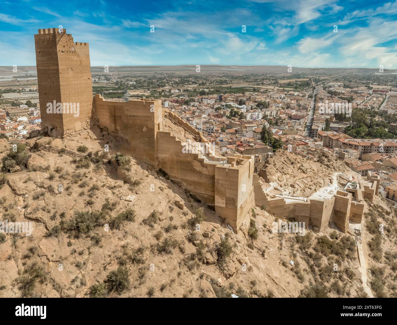 Vista aerea del castello di Alhama con una grande piazza restaurata utilizzando cemento e rovine di insediamenti iberici nella provincia di Murcia della Spagna meridionale. Foto Stock