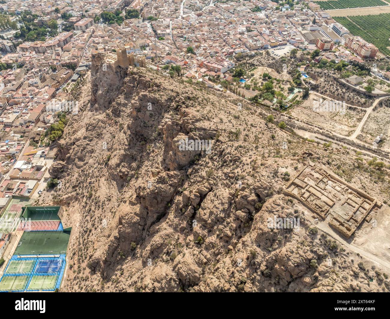 Vista aerea del castello di Alhama con una grande piazza restaurata utilizzando cemento e rovine di insediamenti iberici nella provincia di Murcia della Spagna meridionale. Foto Stock