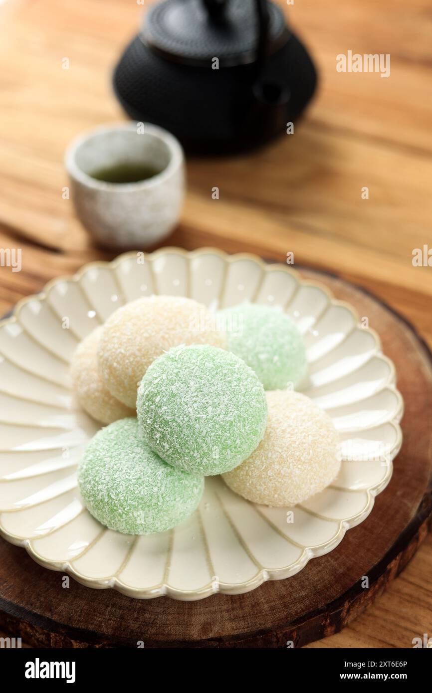 Mochi giapponese con rivestimento di cocco secco, servito con tè Matcha Foto Stock