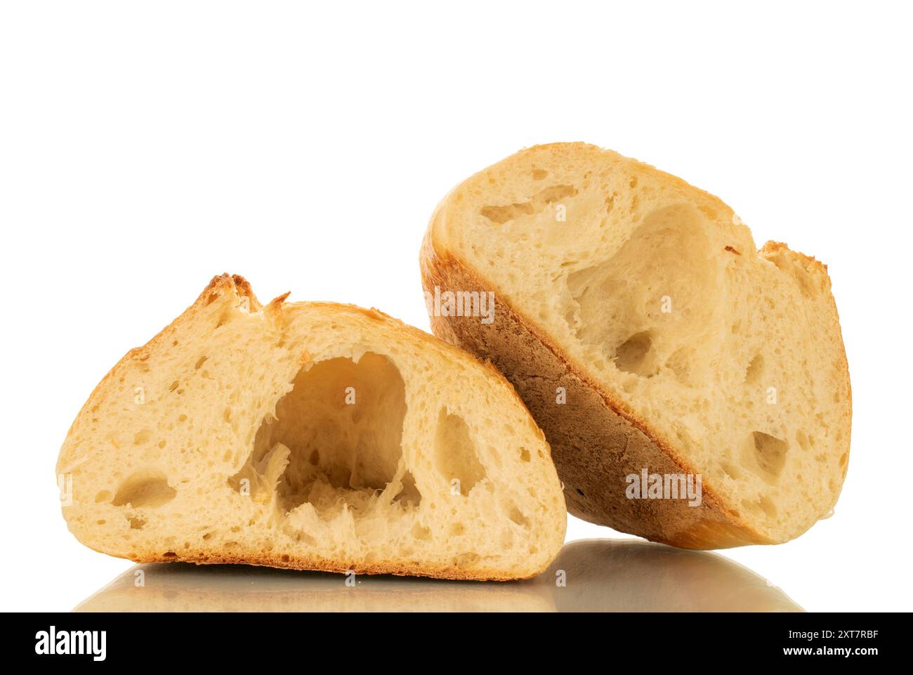 Una pagnotta di grano tagliata a metà, macro, isolata su sfondo bianco. Foto Stock