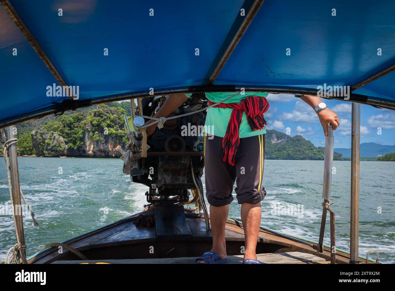 Phuket Thailandia ritratto dell'uomo che guida la barca in un giorno d'estate. I pescatori guidano una tradizionale barca tailandese a coda lunga in Thailandia. Foto di viaggio Foto Stock