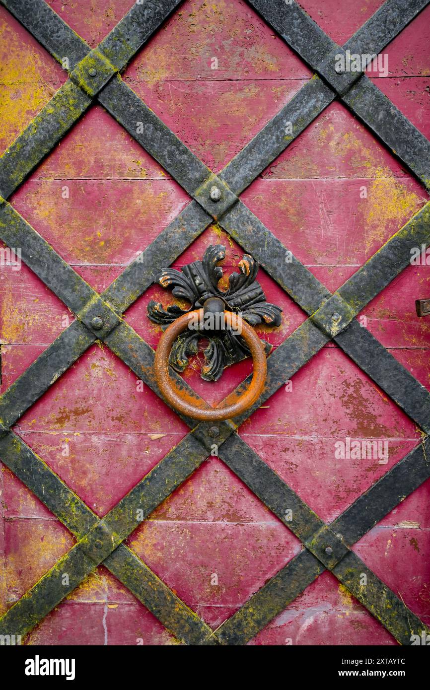 Elemento decorativo artistico su una vecchia porta in metallo arrugginito. Bussano alla porta. Foto Stock