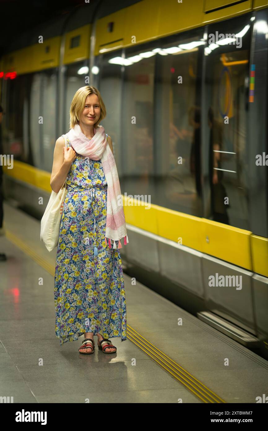 Una donna sta in metropolitana, in attesa della metropolitana. Foto Stock