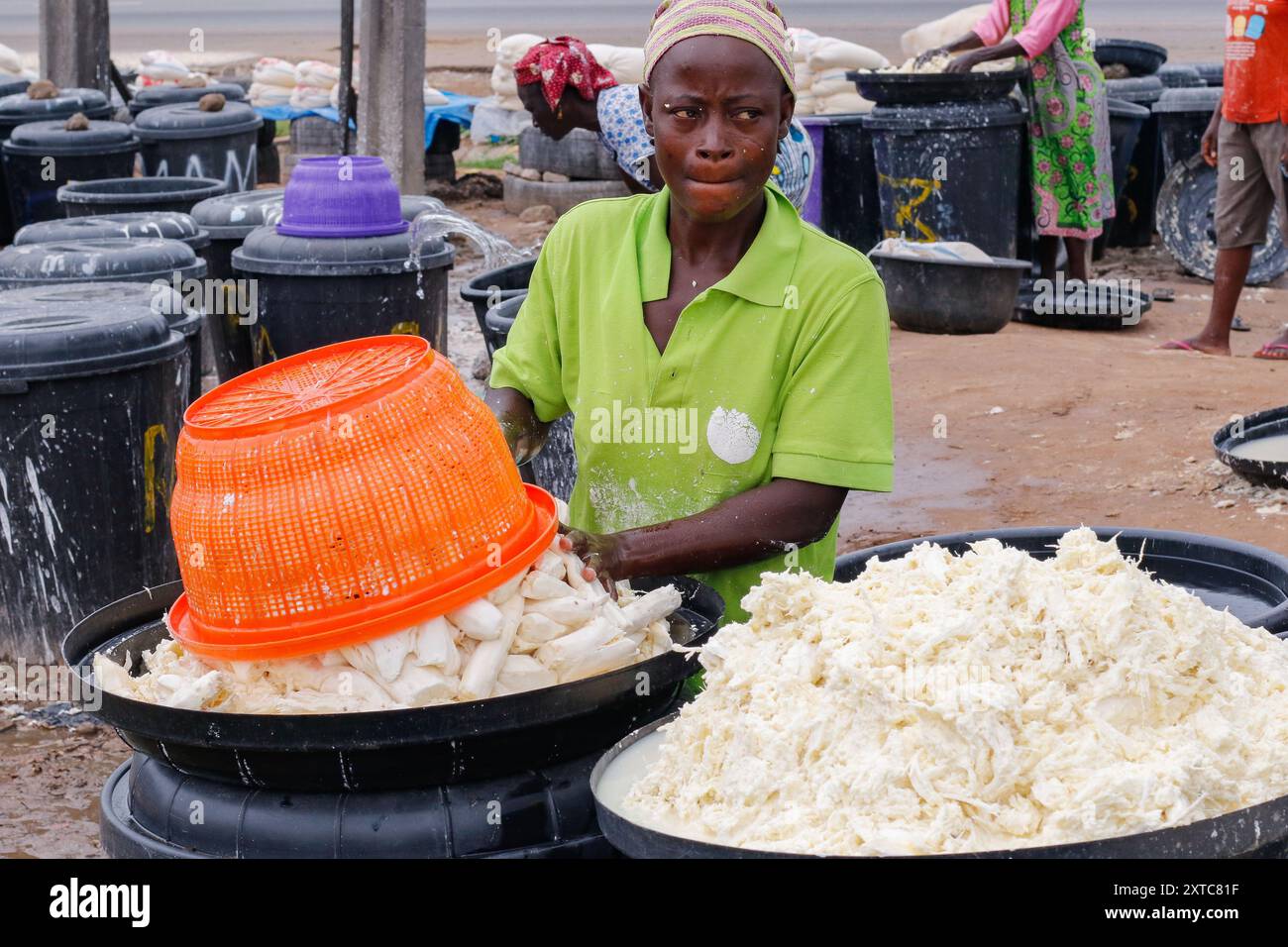 Le femmine di Abuja stanno lottando e facendo passi da gigante in una fabbrica locale di lavorazione della manioca in condizioni difficili per produrre farina mentre lavano la pula dalla manioca fermentata. Di fronte alle incertezze economiche, queste giovani ragazze e donne stanno affrontando varie sfide per rafforzare se stesse, fornire lavoro agli altri e sostenere il sostentamento. La maggior parte delle donne qui sono costrette a vivere, e si battono per le loro famiglie. Nigeria. Foto Stock