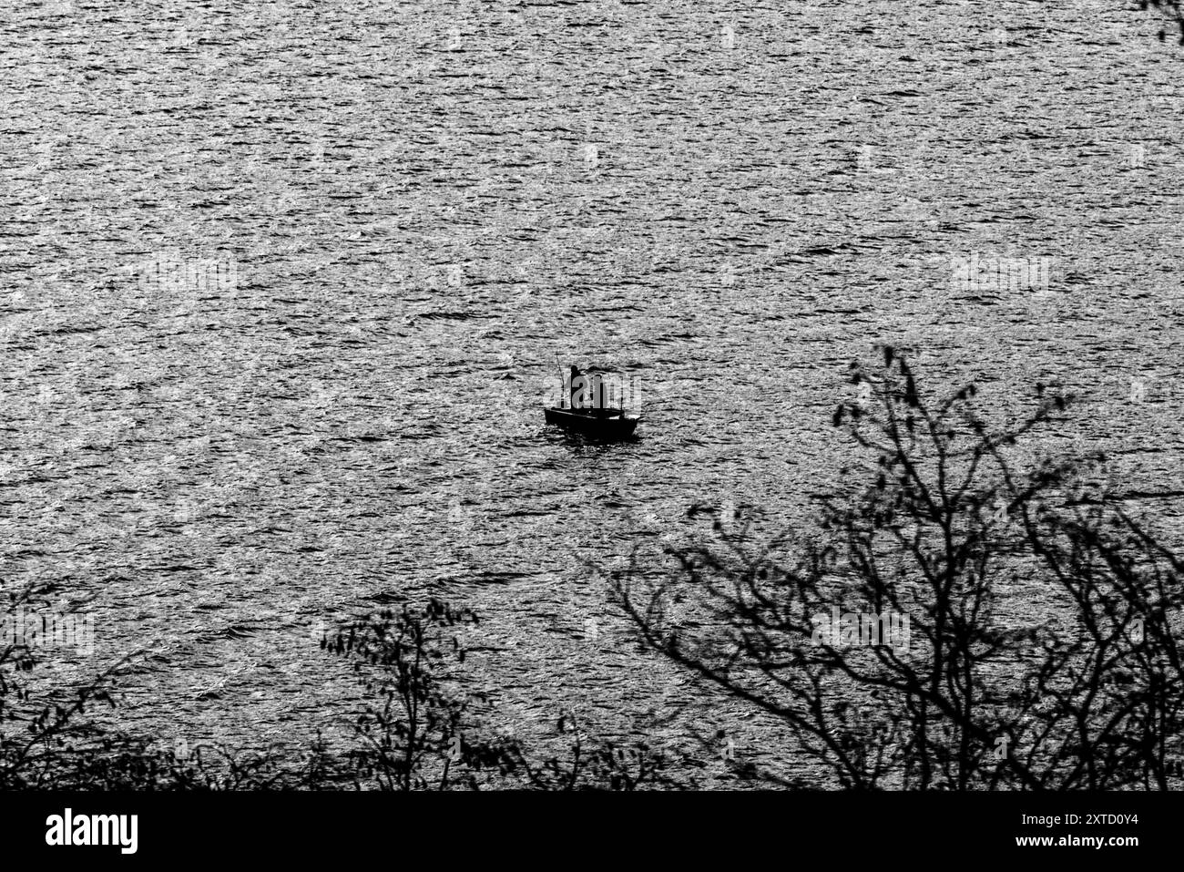 Piccola barca con pescatori nel lago di Lecco in inverno a Lecco in Italia Foto Stock