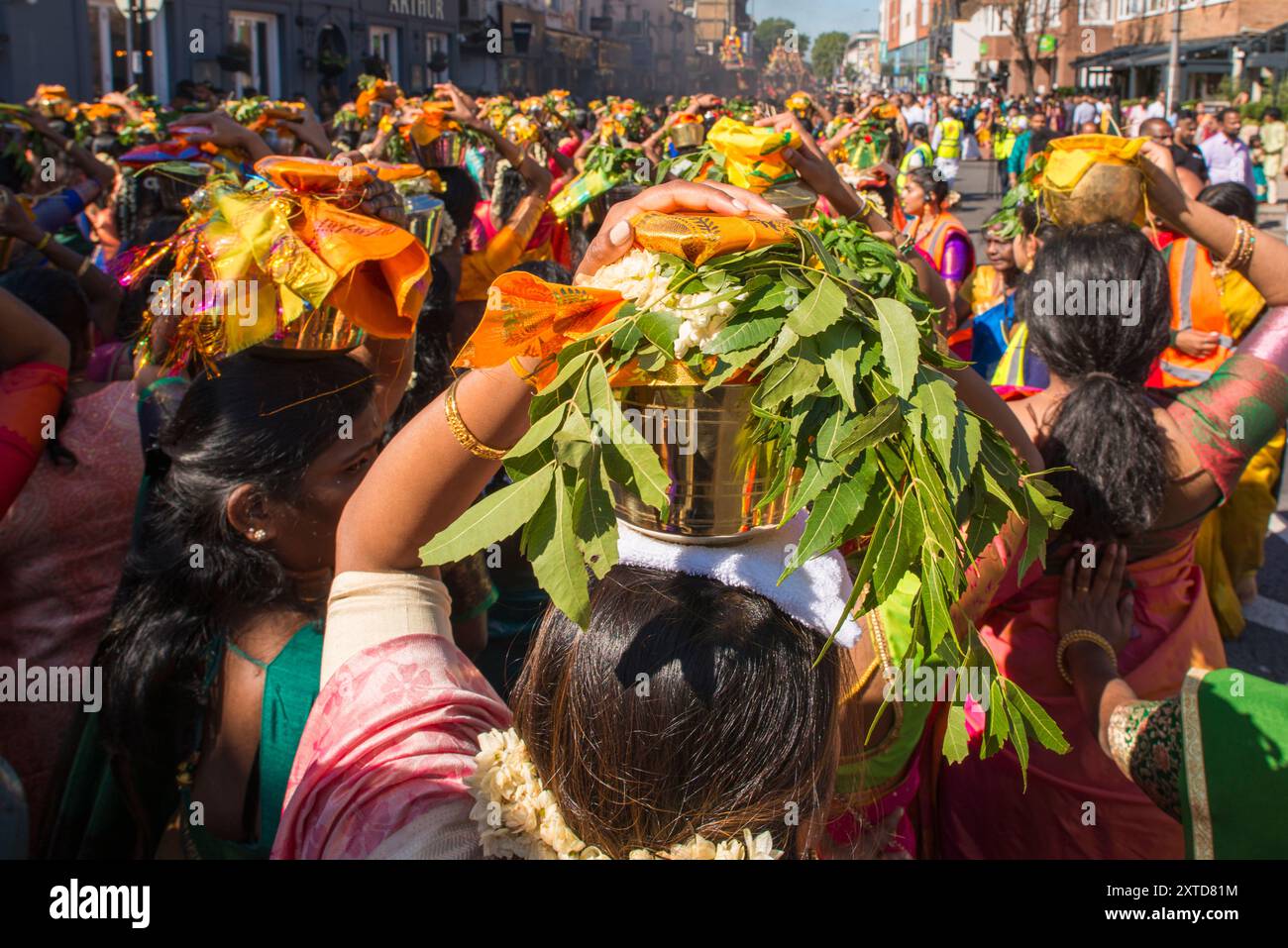 Tamil Chariot Festival, Ealing, donne dedite che camminano all'indietro di fronte ai carri, trasportando vasi di latte, noti come "paal kudam", sulle loro teste. Foto Stock