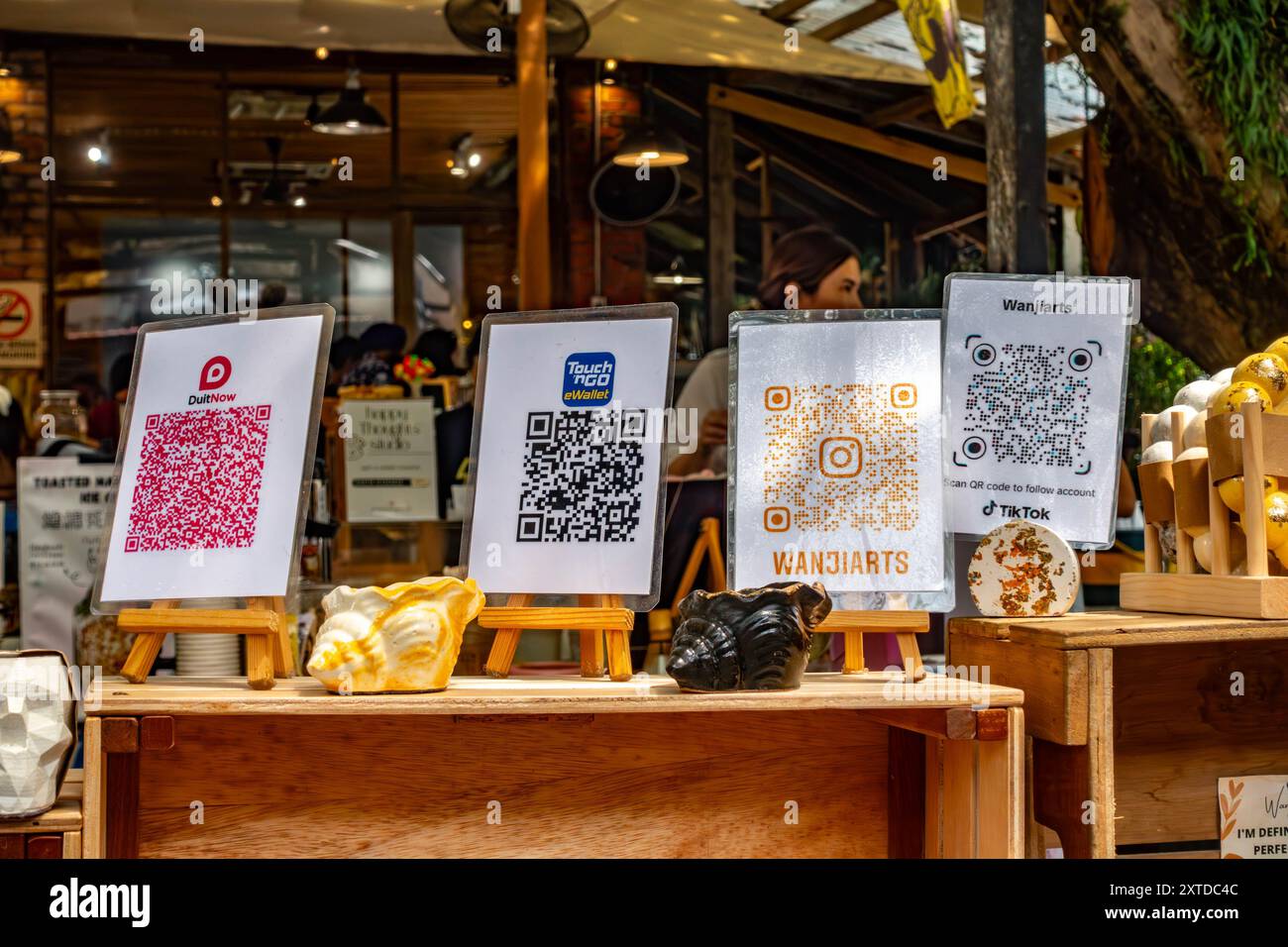 Una sezione di codici QR colorati in una bancarella del mercato da scansionare con un telefono cellulare per accedere alle opzioni di pagamento e alle informazioni. Foto Stock