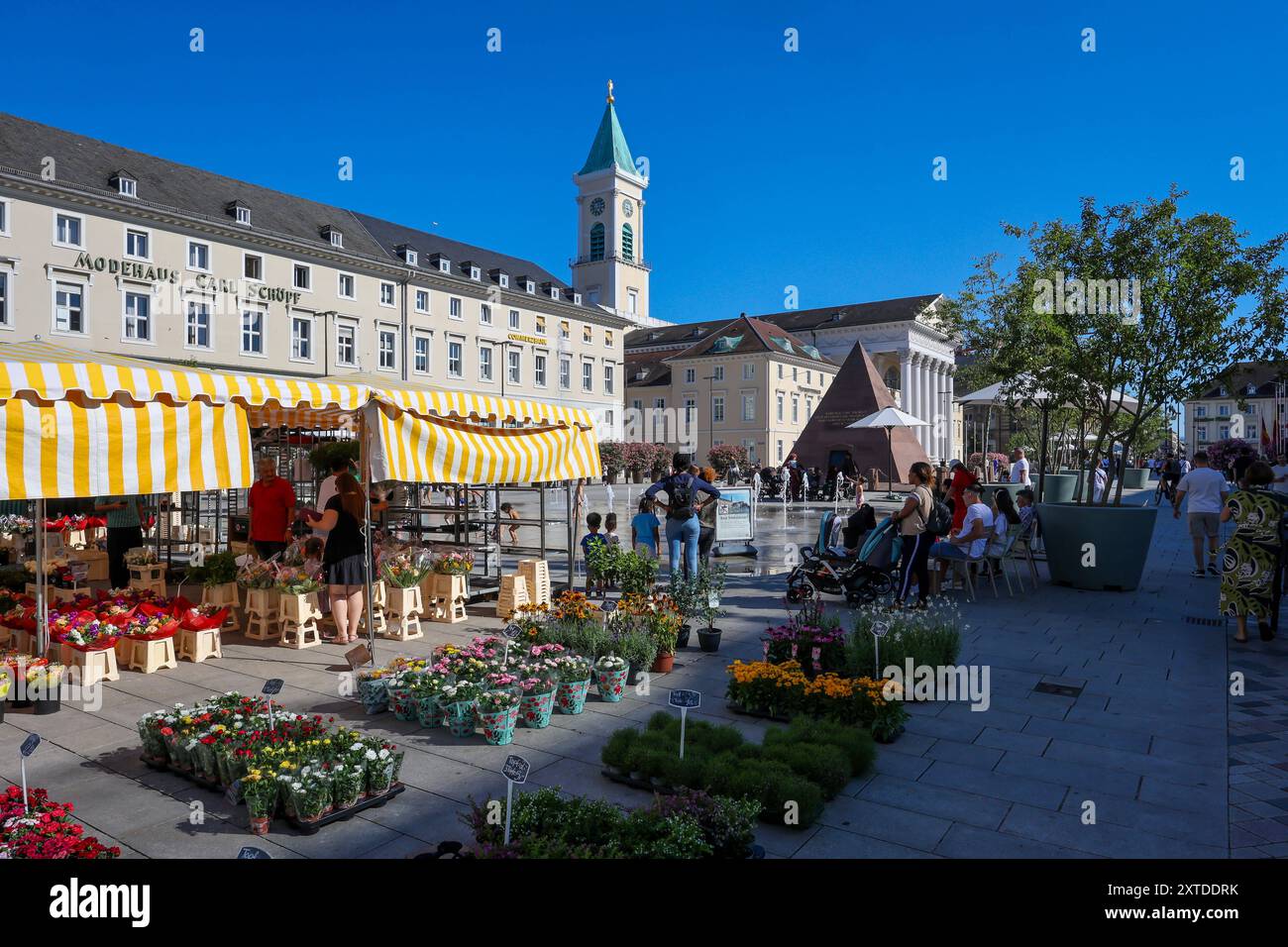 Karlsruhe, Baden-Württemberg, Deutschland - Marktstand mit Blumen am Marktplatz mit Pyramide und hinten der Stadtkirche Karlsruhe. Die Karlsruher Pyramide auf dem Marktplatz an der Karl-Friedrich-Straße ist das Grabmal vom Stadtgruender Karl Wilhelm von Baden-Durlach 1679 1738 und ein Wahrzeichen der Stadt. Karlsruhe Baden-Württemberg Deutschland *** Karlsruhe, Baden Württemberg, mercato tedesco bancarelle con fiori sulla piazza del mercato con piramide e dietro la chiesa della città Karlsruhe la piramide di Karlsruhe sulla piazza del mercato di Karl Friedrich Straße è la tomba del fondatore della città Karl Wilhelm Foto Stock