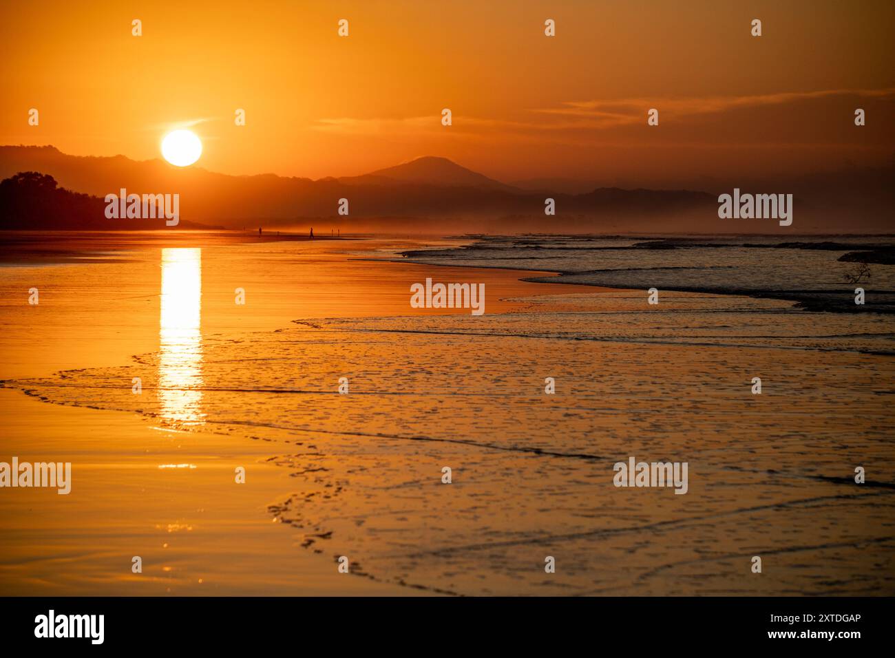 Tramonto sulla spiaggia di Santa Luca’a, Panama. Le persone camminano sulla spiaggia, con la silhouette in lontananza. Foto Stock