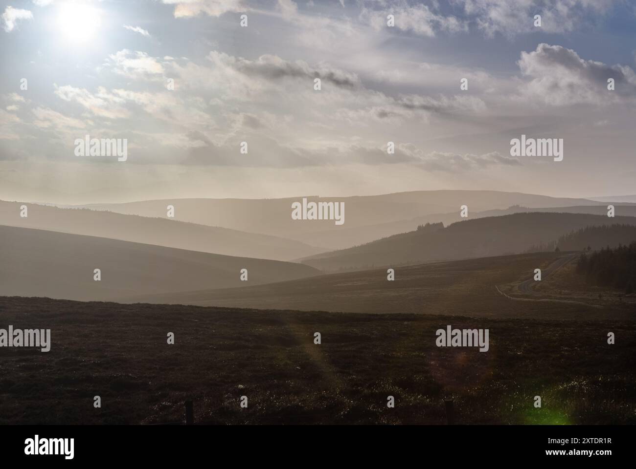 Tramonto sulla campagna nebbiosa di Kielder, Northumberland, catturando il tranquillo paesaggio sotto un cielo pieno di nuvole Foto Stock