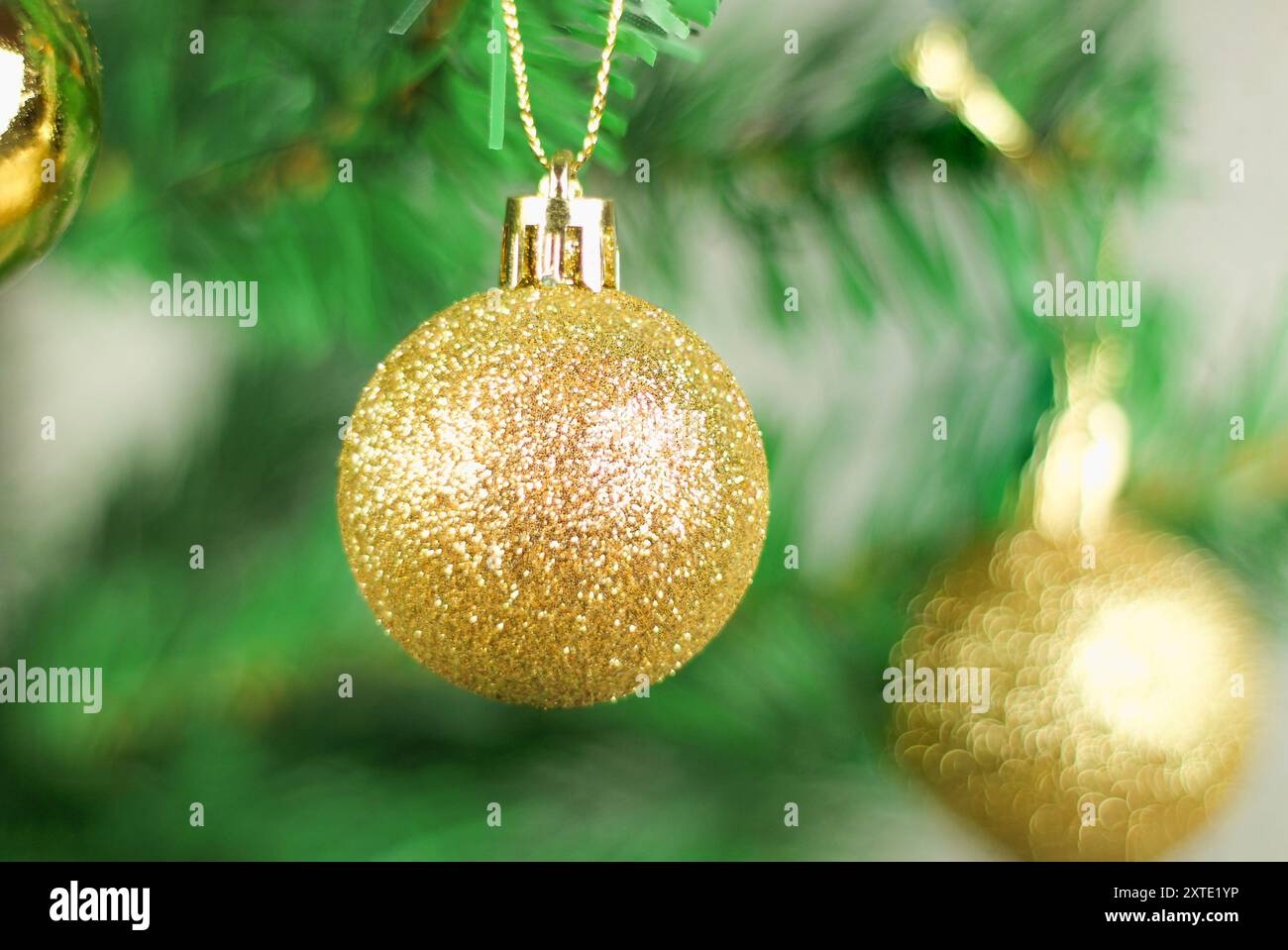 Idea del nuovo anno. Palle d'oro sull'albero di Natale isolate su sfondo grigio. Preparazione per la celebrazione del nuovo anno. Foto Stock