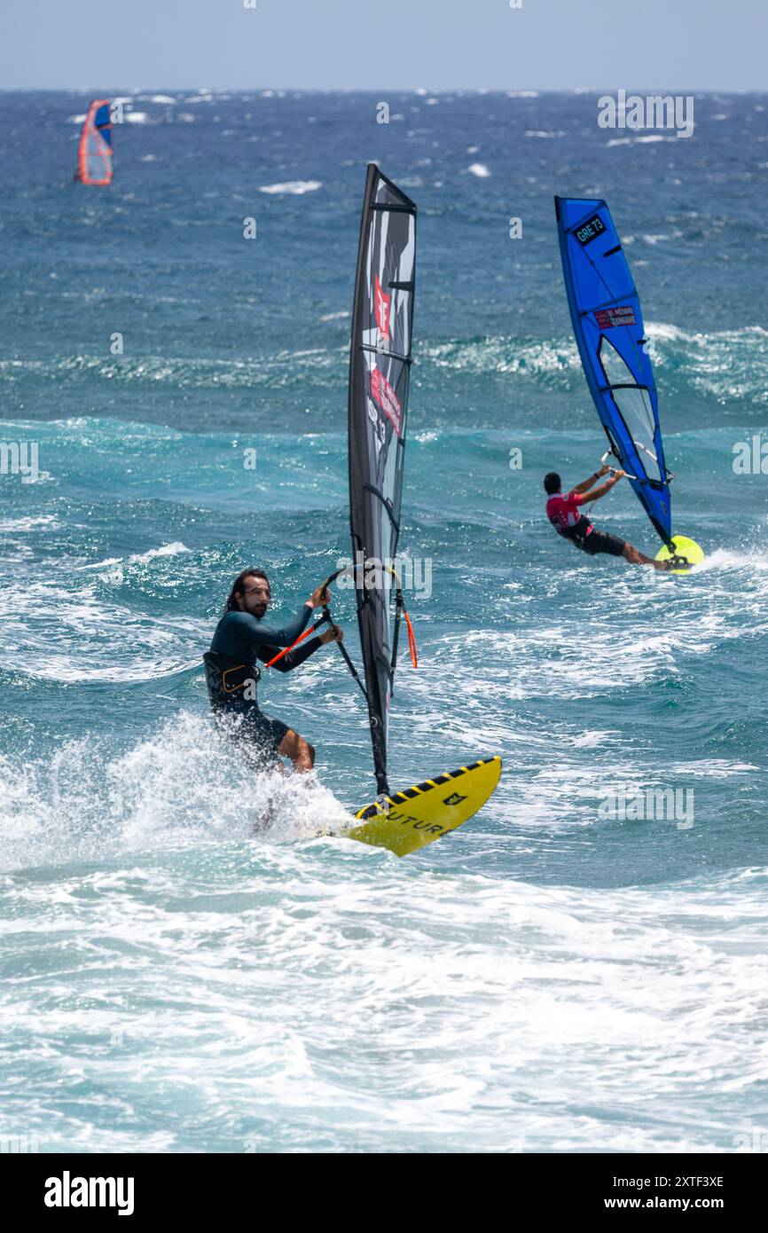 I partecipanti si sfidano al Campionato del mondo di Windsurf a El Medano, Tenerife, Spagna, mettendo in mostra abilità emozionanti ed energia vibrante sulle onde. Foto Stock