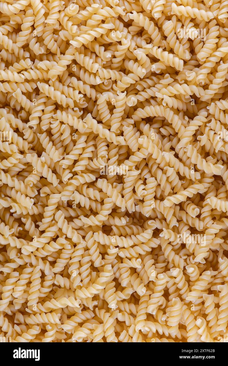 Pasta fusilli. Pasta secca cruda italiana fusilli con consistenza naturale o fondo, primo piano, alta risoluzione. Foto Stock