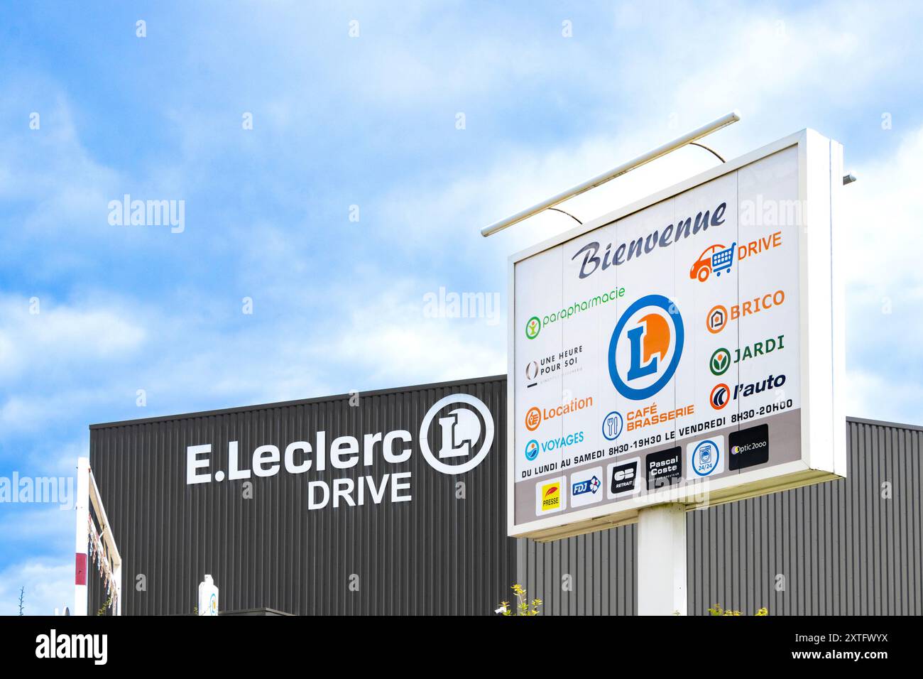 Fotografia dell'ingresso anteriore e segnaletica della E.. Negozio Leclerc Drive con logo di vari servizi e marchi contro un cielo blu. Foto Stock