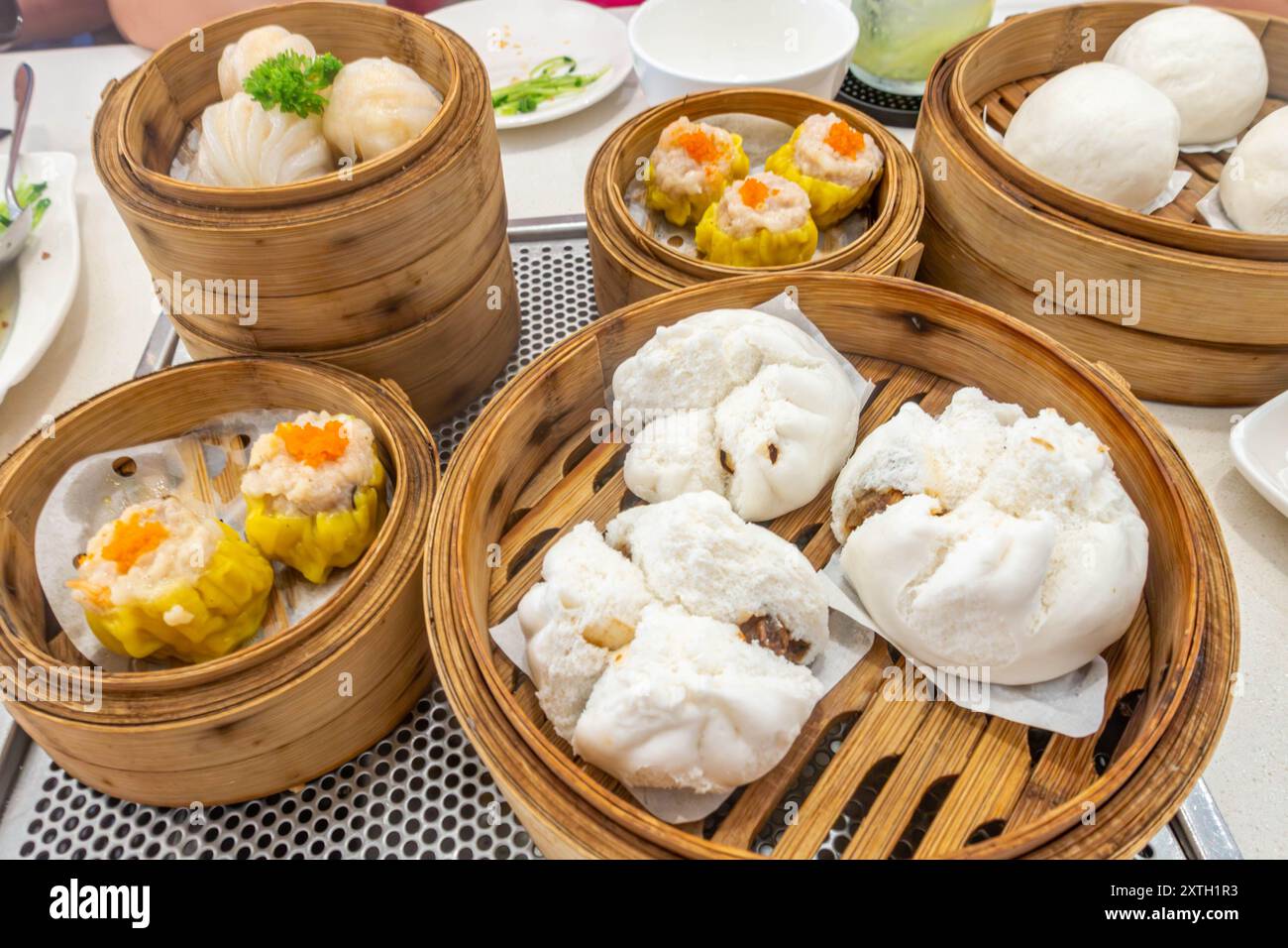 Guardando in basso il dim sum in cesti a vapore su un tavolo in un ristorante a George Town, Penang, Malesia. Foto Stock