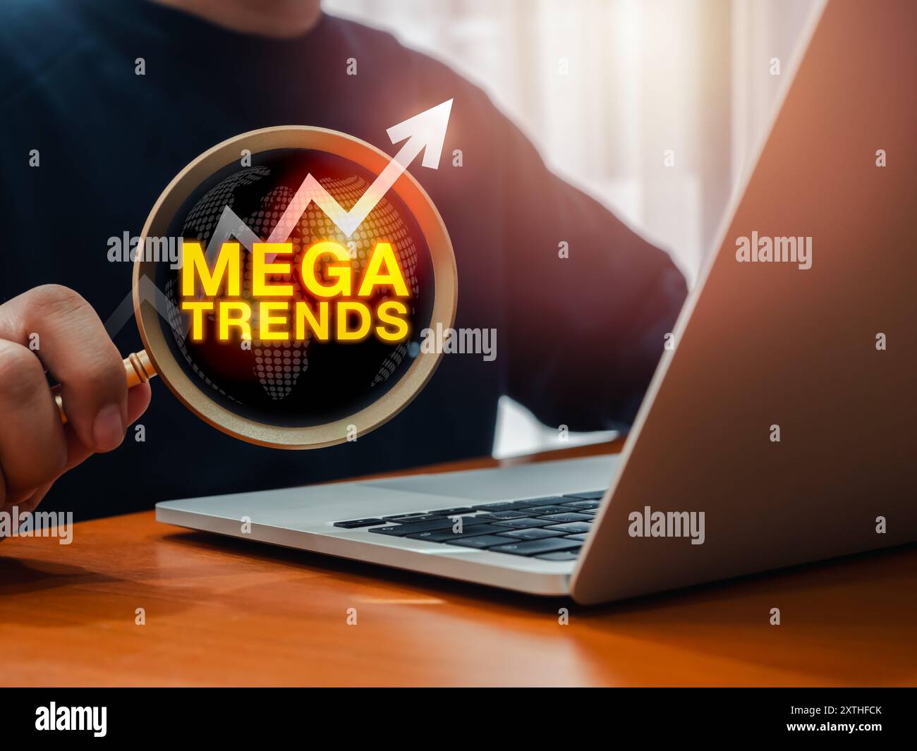Mega trend, business, tecnologia e concetto di trend di marketing. Testo "MEGATRENDS" con freccia del grafico di crescita su una grande lente di ingrandimento in un uomo d'affari Foto Stock