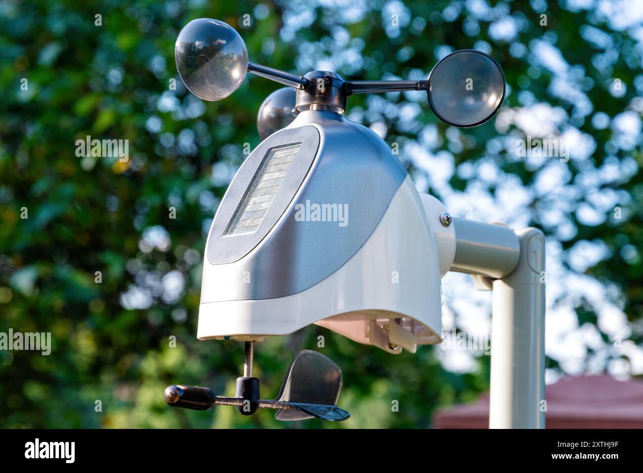 La stazione meteorologica individuale con una pala nera è montata su un palo in un giardino. Meteorologia personale e previsioni meteorologiche Foto Stock