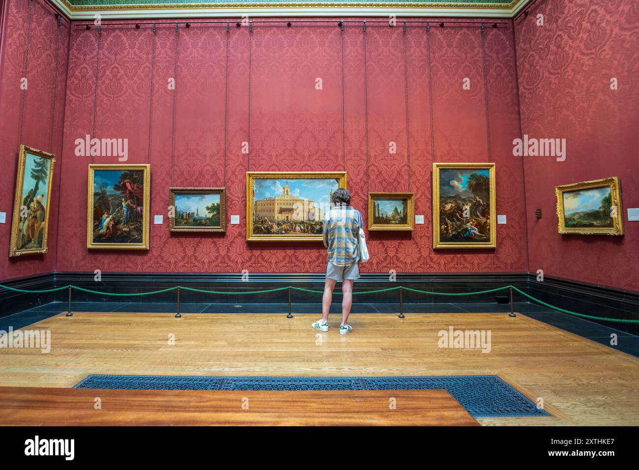 All'interno del museo d'arte National Gallery. Vista interna della mostra della galleria d'arte con diversi dipinti e un giovane che guarda dipinti sulle pareti. Foto Stock