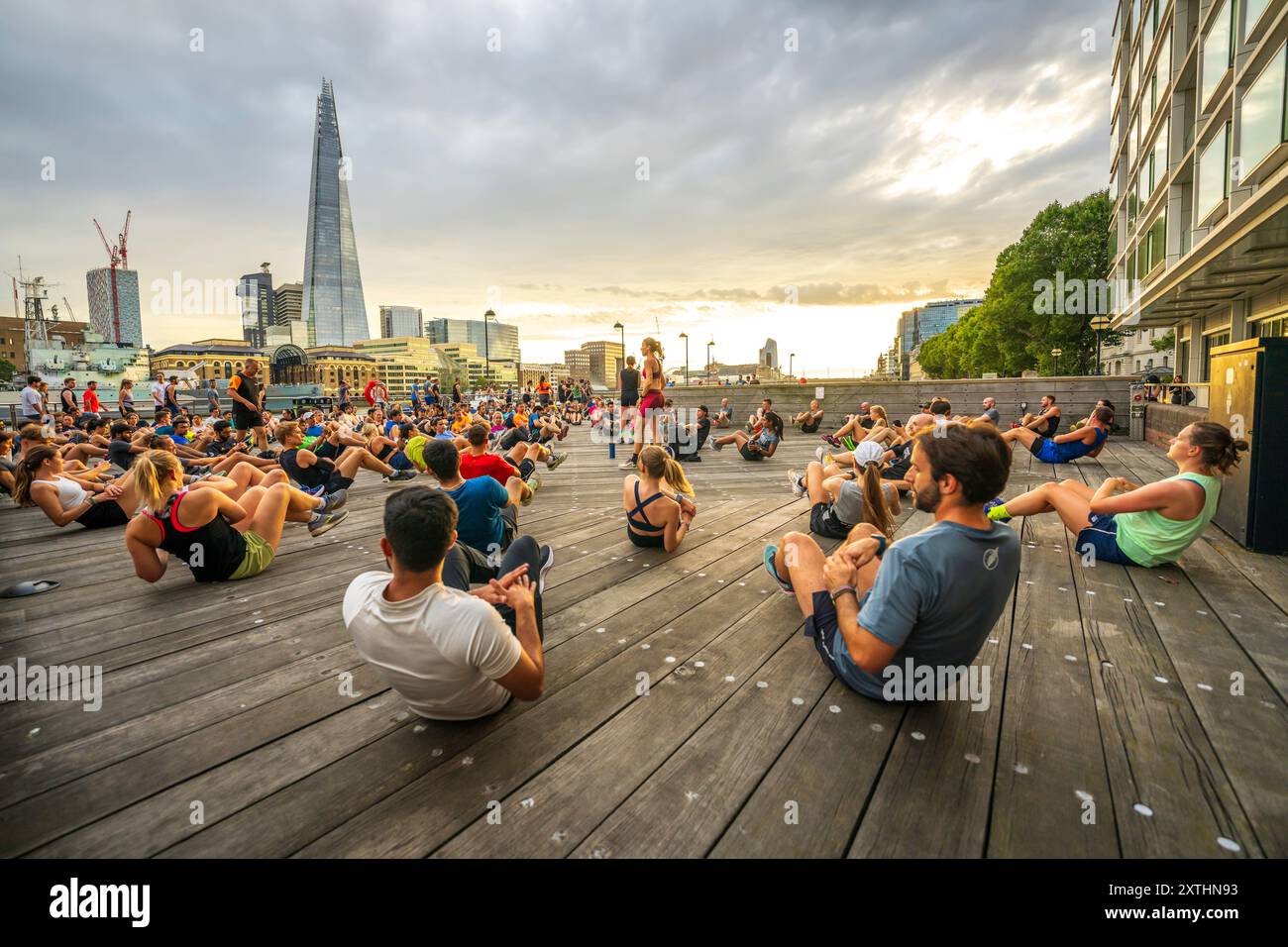 Panorama cittadino di Londra con diversi gruppi di persone che si allenano, lezioni di fitness all'aperto sulla riva del Tamigi con lo skyline di Londra, Shard. Stile di vita. Foto Stock