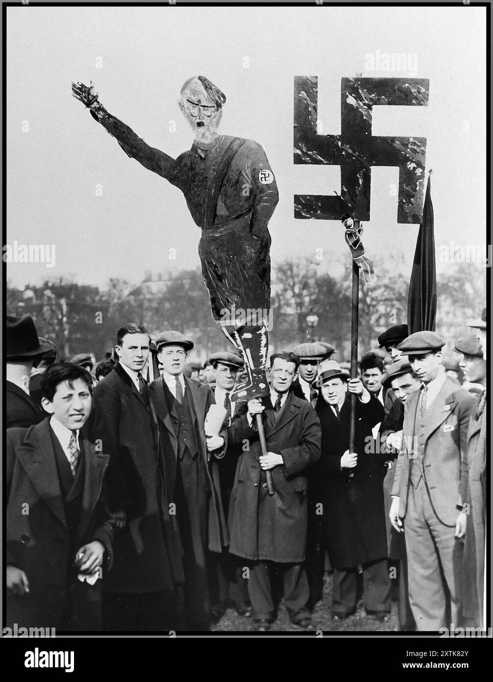 DIMOSTRAZIONE BRITANNICA CONTRO LA PERSECUZIONE NAZISTA PRIMA DELLA GUERRA gli ebrei britannici portano un'effigie di Hitler e una grande svastica in una manifestazione di massa a Hyde Park, dove migliaia di persone sono riunite per protestare contro la persecuzione nazista degli ebrei tedeschi. 1933 Londra, Inghilterra Foto Stock