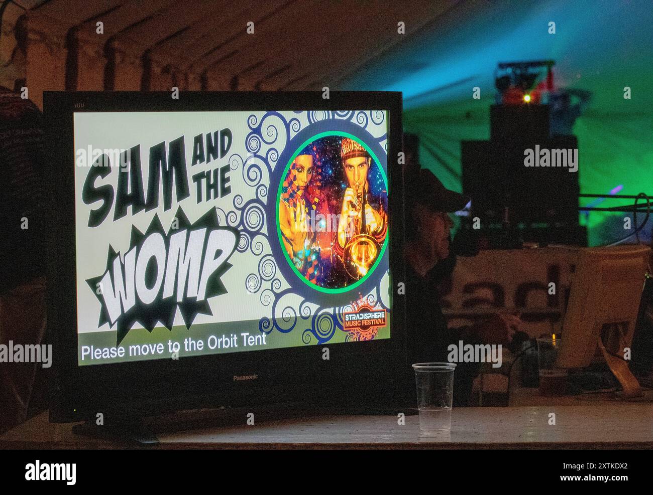 Al festival musicale di Stradisphere del 2018 in un villaggio del Suffolk, uno schermo piatto tecnico annuncia Sam and the Womp sul palco nella tenda di Orbit Foto Stock